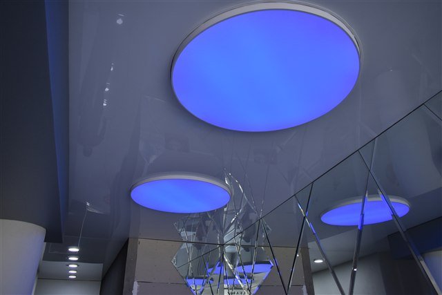 Hall de entrada con cielorraso blanco brillante y círculos RGB
