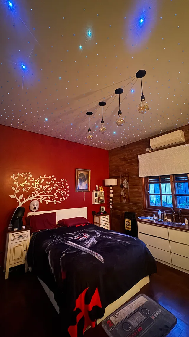 Dormitorio terminado con puntos de luz azules y luminarias colgantes